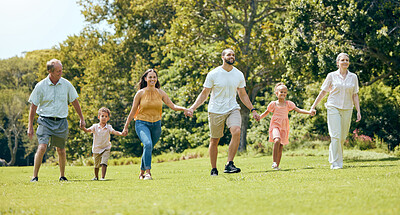Buy stock photo Grandparents, parents and kids walking in the park, happy 
and bonding together outdoor. Family, holding hands and fun being loving, happiness and adventure on vacation, spend quality time and love.