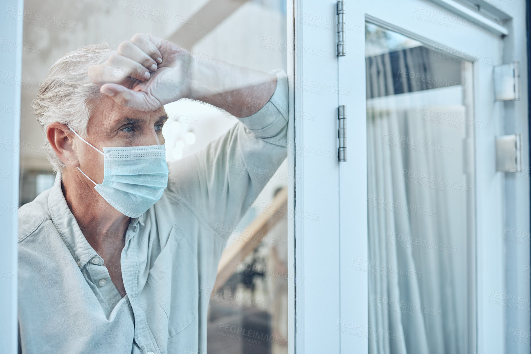 Buy stock photo Lonely, face mask and senior man in the house for quarantine, protection and isolation during pandemic. Depression, frustrated and sad elderly guy with covid looking outside the window at his home.