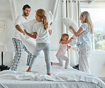 Family, children and pillow fight with parents and girl siblings playing or having fun in a bedroom of the home together. Kids, happy and bonding with a man, woman and daughter sisters playful on bed