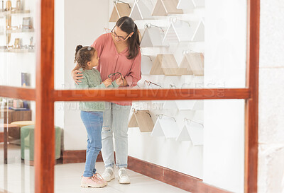 Buy stock photo Mother, girl and shopping, glasses and optometrist for lense, frame and vision together in retail store. Woman customer buy prescription with child for eyesight in optometry shop to choose or choice
