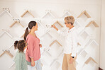 Eye care, mother and child shopping for glasses at the optometrist store shelves with an optician for healthy vision. Customer, mom and young kid searching for frames at a shelf with an eye doctor 