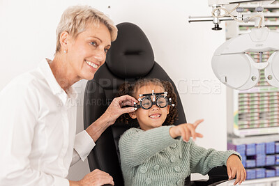 Buy stock photo Child, eye exam and ocular health with ophthalmologist doing vision test for glasses during consultation. Happy girl with eye care optometry specialist woman helping patient for wellness and health