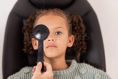 Buy stock photo Optometry, eye care and girl getting a vision test with a occluder in a medical optical clinic. Checkup, optometrist and child from Brazil doing a eye exam with a optic tool for healthy eyesight.
