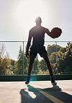 Basketball, sports and man in a park for training, cardio and exercise with a ball during summer. Dark silhouette of a professional athlete with freedom and energy for a sport on a basketball court