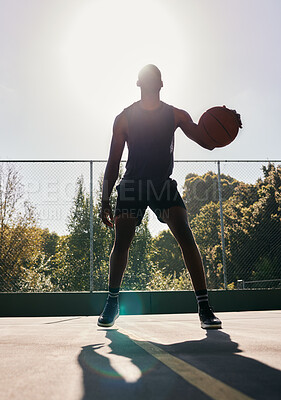 Buy stock photo Basketball, sports and man in a park for training, cardio and exercise with a ball during summer. Dark silhouette of a professional athlete with freedom and energy for a sport on a basketball court