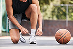 Basketball, shoes and hands by man on the ground for lace before exercise, training and cardio at a basketball court. Fitness, sneakers and basketball player getting ready for workout, sport and game