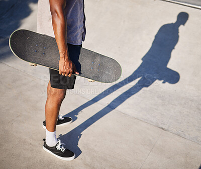 Buy stock photo Skateboarding, sport and man holding a board for fun, riding and playing at a park. Legs, shadow and cool skater or skateboarder skating with a skateboard for sports and style in the urban city