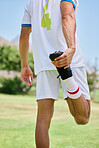 Soccer, sports and athlete stretching his leg before a match, training or practice on an outdoor field. Football, workout and man doing a warm up exercise for game or workout on a pitch at a stadium.