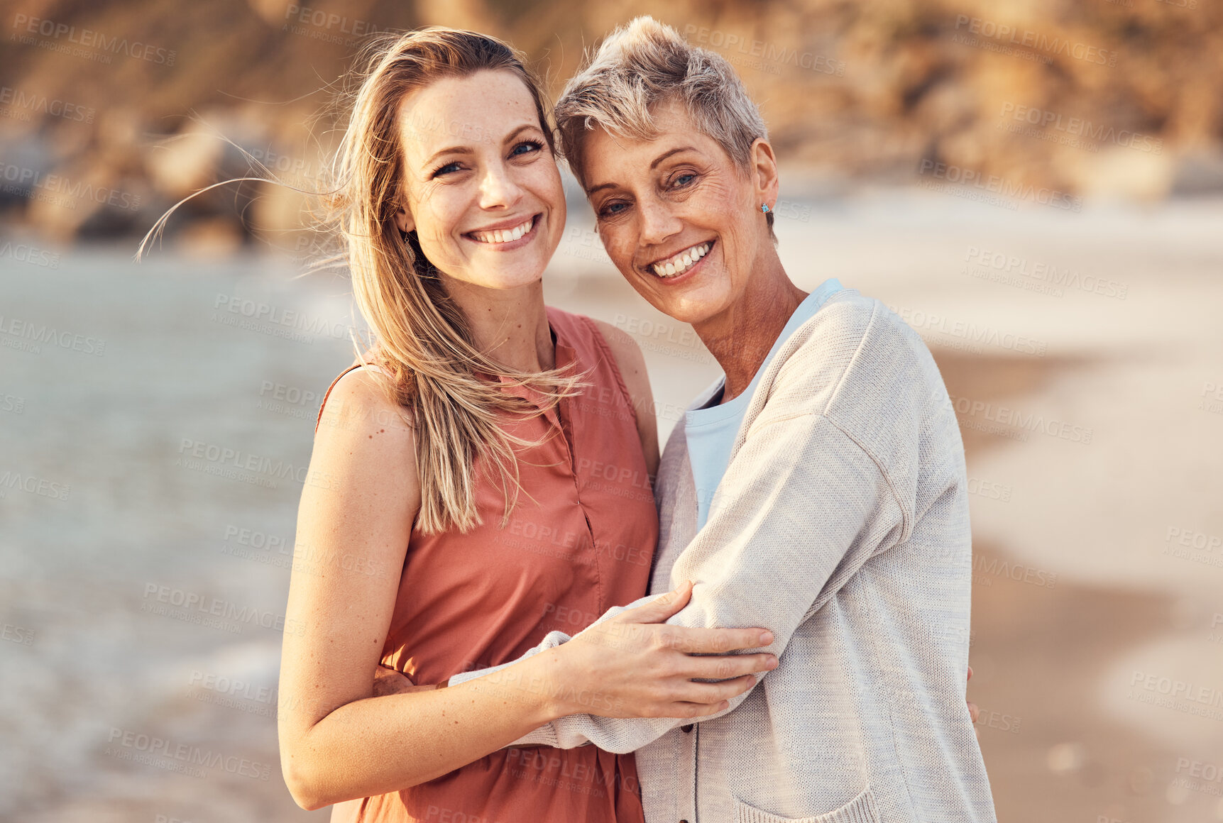 Buy stock photo Women, mom and daughter hug on beach enjoy nature and family time together on the shore with smile. Love, water and portrait of woman hugging senior mother on happy ocean holiday and walk on sea sand