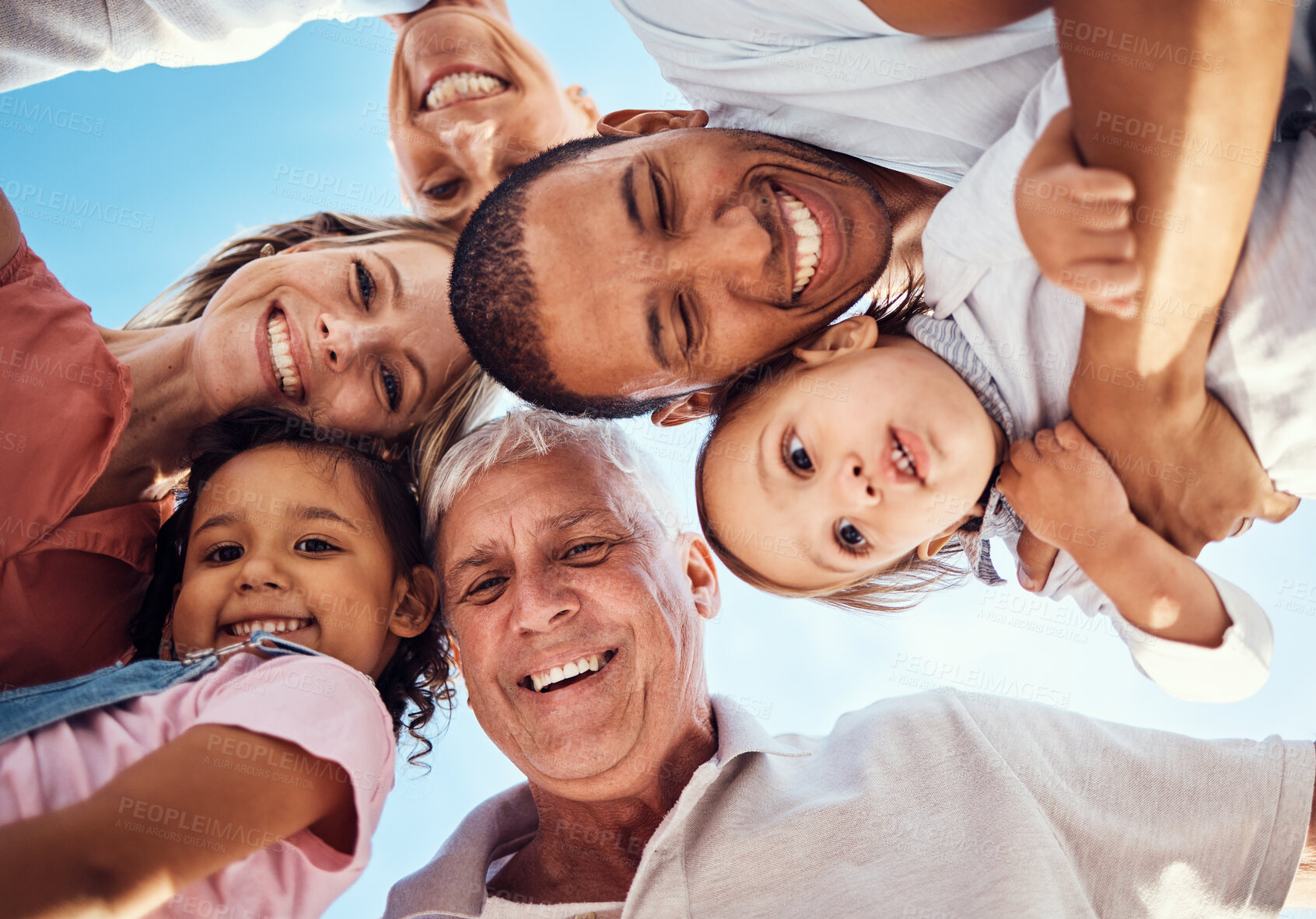 Buy stock photo Diversity, huddle and family with smile, happy and bonding together for vacation, spend quality time and joyful. Interracial, grandparents or parents with kids being cheerful, happiness and low angle