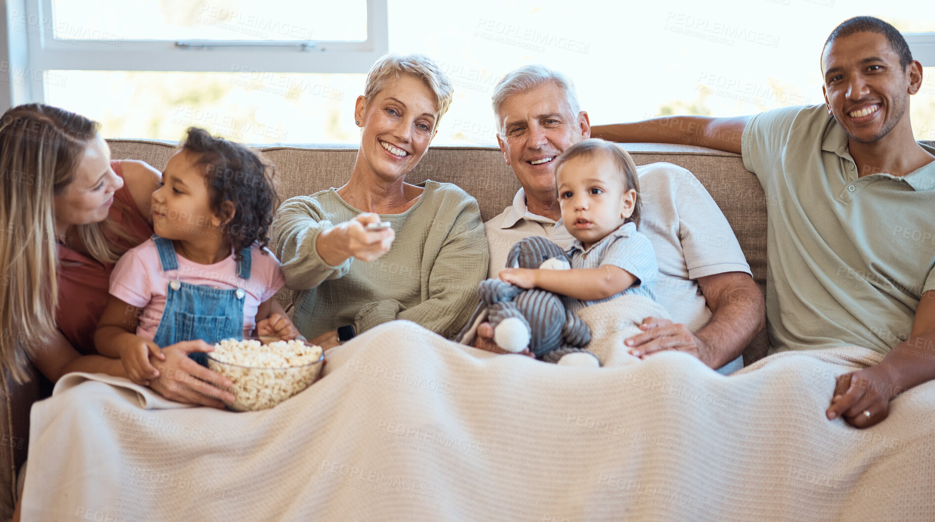 Buy stock photo Happy family on sofa watching tv with popcorn and kids show, film or comedy movie on live streaming service. Television, relax and grandparents with children on couch with love, diversity and talking