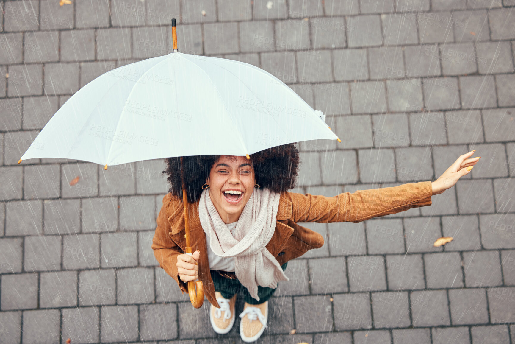 Buy stock photo Black woman, umbrella and rain with smile, happy and enjoy weather in city being wet. Winter, young female and happiness for storm, cheerful and joyful with cover, comfortable and rainy outdoor.