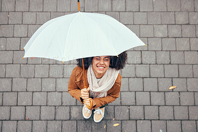 Buy stock photo Happy, relax and girl with rain umbrella enjoying outdoor, urban and winter weather with excited smile. Happiness, peace and wellness of black woman with afro standing in rainy city top view.

