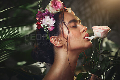 Buy stock photo Beauty, nature and flowers with a model woman biting a rose in studio on a natural forest background. Skincare, wellness and luxury with an attractive young female posing in a rainforest jungle