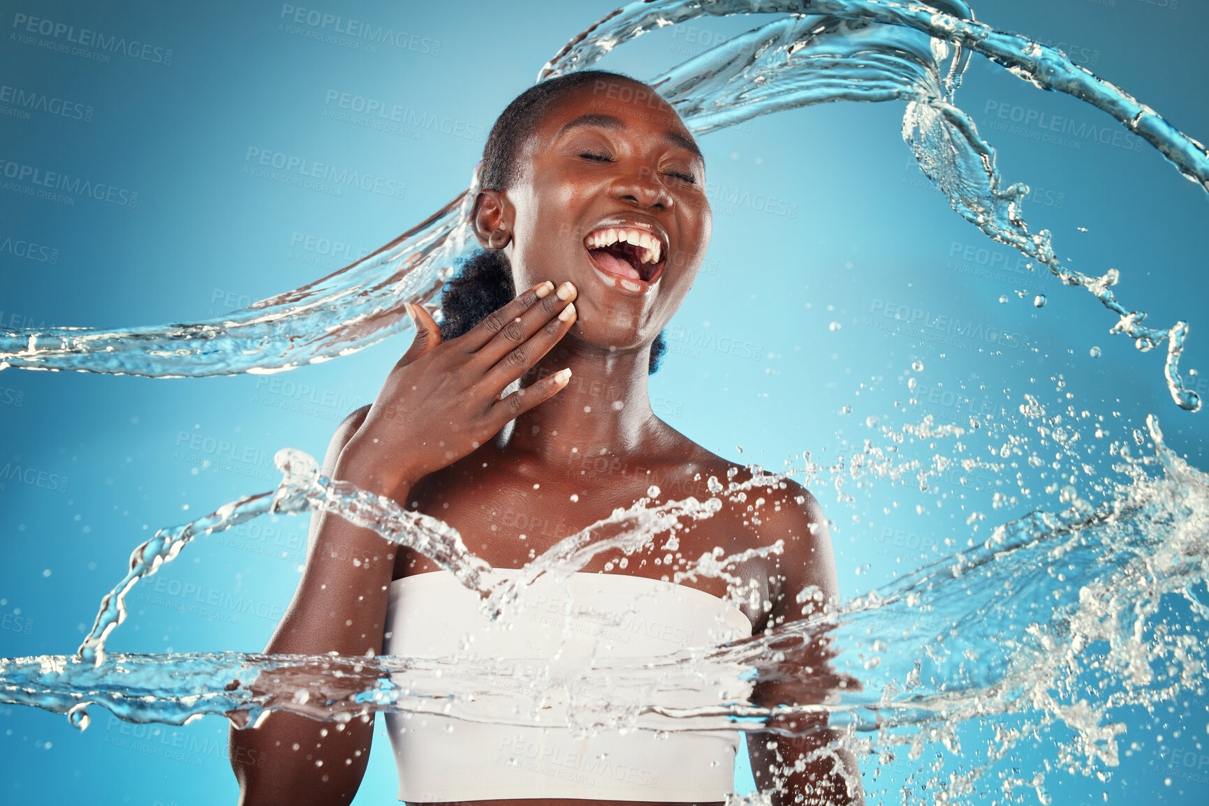 Buy stock photo Water, splash and woman washing for hygiene and grooming on a blue studio background. Young black woman wash, cleanse and cleansing body and skin for bodycare, skincare and health or wellness 