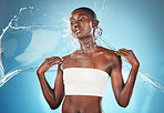 Splash, skincare and black woman with water for wellness, beauty and dermatology against blue studio background. Spa, thinking and African girl model with idea for fresh, natural and body hydration