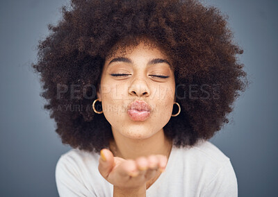 Buy stock photo Kissing, love and romance with a black woman blowing a kiss in studio on a gray background for romantic affection. Beauty, lips and flirt with an attractive young female making a mouth gesture