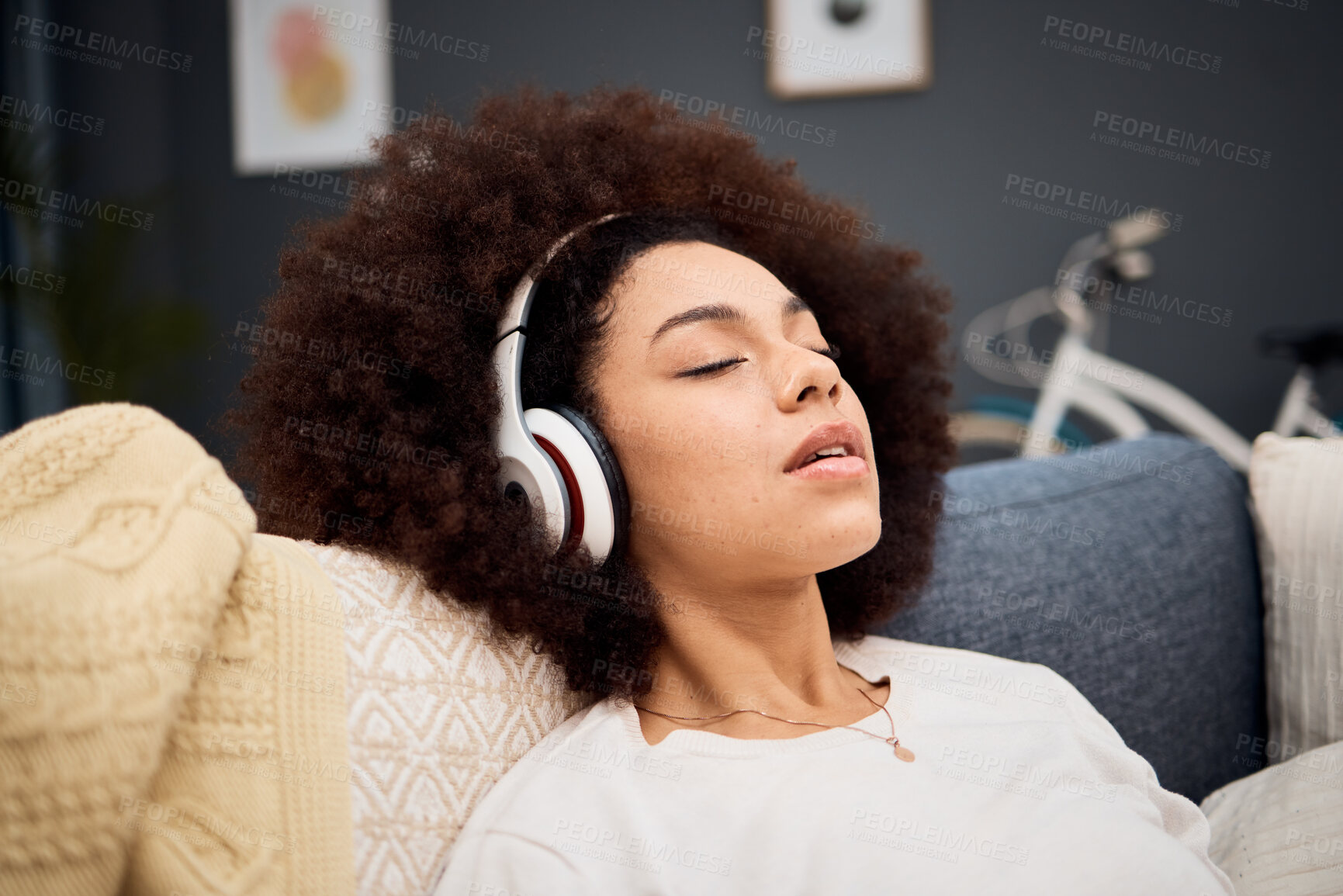 Buy stock photo Music, relax and black woman on a sofa listening to radio, streaming or wellness podcast in a living room. Headphones, woman and rest on a couch with online audio track, meditation and playlist 