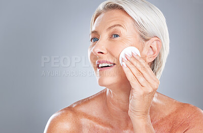 Buy stock photo Cotton pad, skincare and senior woman in studio for beauty, cleaning and grooming on grey background mockup. Face, cotton and elderly model relax with product, cleanser and hygiene, skin and wellness