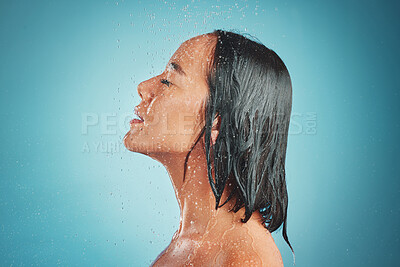 Buy stock photo Woman, hygiene and wet shower for relax, beauty or fresh clean with water drops against a blue studio background. Relaxed female enjoying a hygienic wash and liquid sensation in cleanliness on mockup