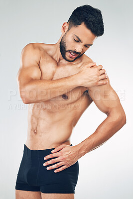 Buy stock photo Shoulder pain, injury and fitness man in underwear in mockup studio background. Inflammation, hurt muscle and a male model with muscular body in holding his arm, health and body care after workout