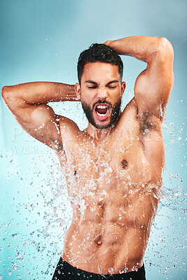 Buy stock photo Muscular man, water splash and health for wellness, fitness and hygiene with blue studio background. Sing, athlete male and bodybuilder enjoy shower, wash clean or excited for body care after workout