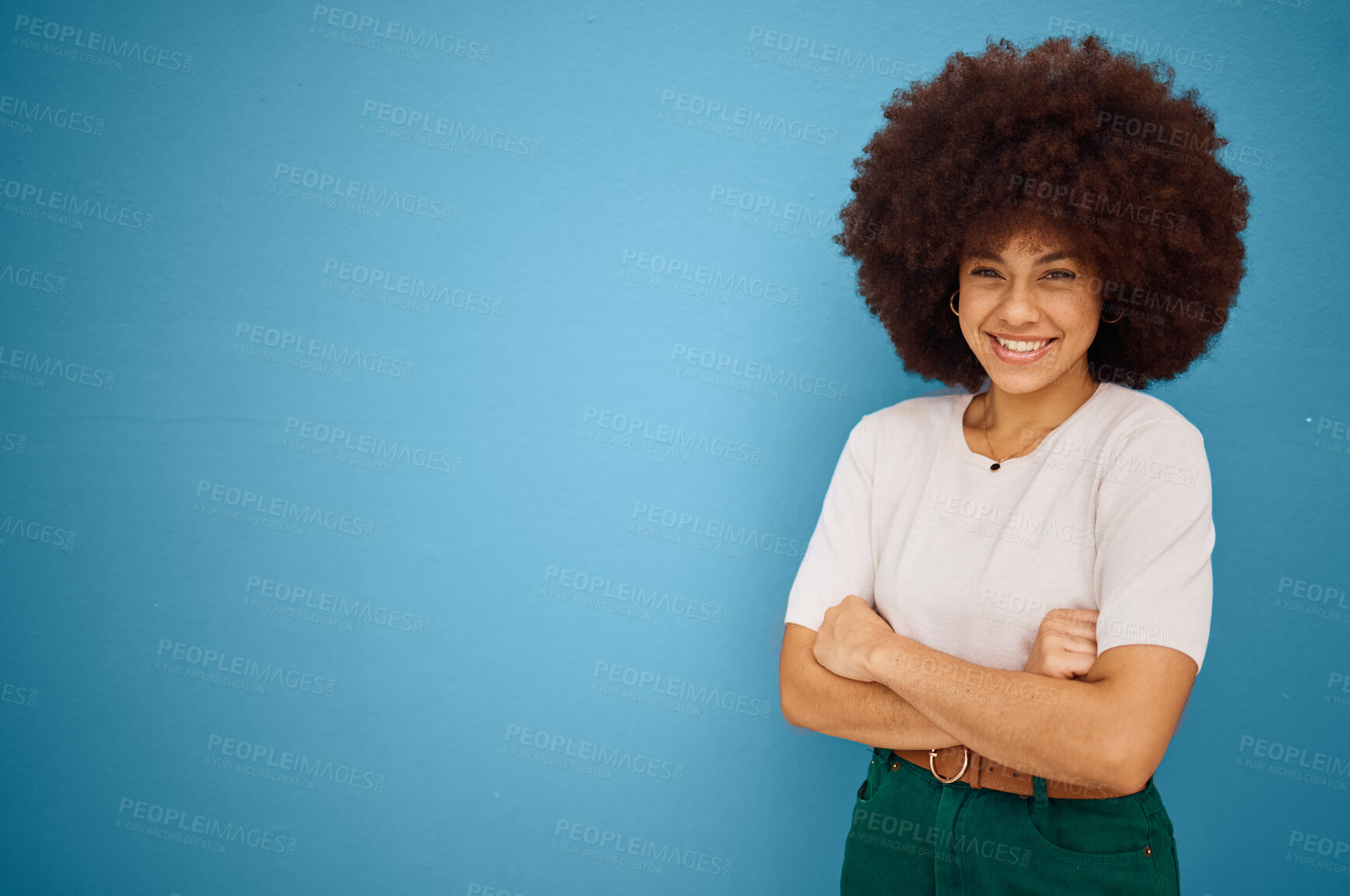 Buy stock photo Black woman, arms crossed and natural hair or afro happiness by marketing, advertising or mockup space on blue studio background. Portrait of a happy model showing smile and promotion mock up