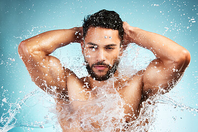 Buy stock photo Water, splash and man washing his body on a blue studio background for health and wellness. Bodycare, hygiene and man cleaning or cleansing his body for beauty, wash and clean fresh routine