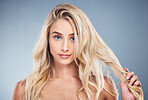 Woman, blonde, hair care on gray studio background in hair dye advertising, treatment or texture hair style. Portrait, beauty model or face with makeup cosmetics, healthy skincare or long hair growth