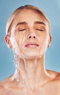 Buy stock photo Water, skincare and face of a woman with a splash for cleaning, treatment and care against a blue studio background. Wellness, health and girl model with luxury facial dermatology to relax for beauty
