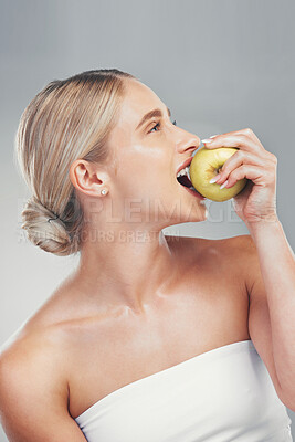 Buy stock photo Nutrition, smile and woman eating an apple for health of teeth, dental and care for body against a grey studio background. Food, diet and happy model thinking of healthy lifestyle with a fruit