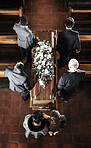 Funeral, coffin and family mourning death of loved one, death and carrying wood casket in church for faith wake, eulogy and memorial. Pallbearers, spiritual grief and sad friends with a flower wreath