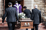 Death, funeral and holding coffin in church for grief, bereavement and with family together on steps. Grieving, sad and congregation in mourning, sad and with goodbye before burial and brown casket.