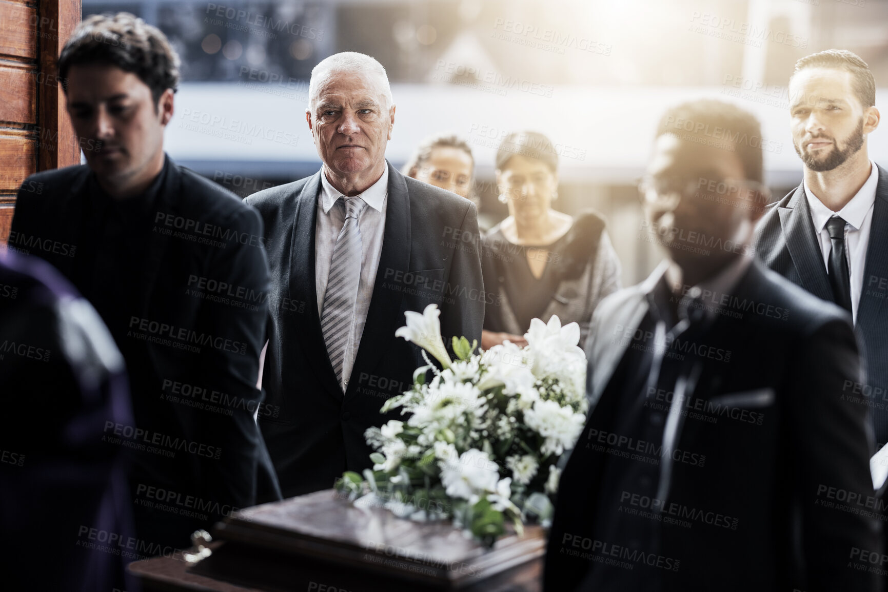 Buy stock photo Sad, funeral and people with coffin at church for service, mourning and grief over death. Flowers, depression and ceremony with family carrying casket in chapel for sorrow, support and loss together