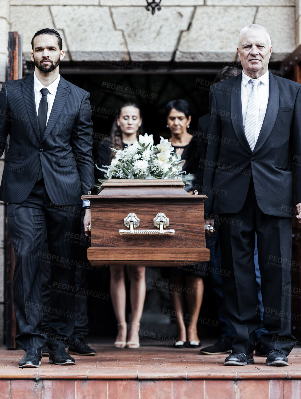 Buy stock photo Funeral, church and people with a coffin, family and mourning in emotional distress. Church service, casket and burial with sad men and women carrying dead person together out of a chapel door