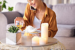 Woman, candles and phone call with smile, happy and content being peaceful, relax or in living room. Female, light and smartphone for conversation, champagne and talking for joy or cheerful in lounge