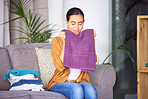 Woman, cleaning and smell towel, fresh and clean laundry in home with happy smile. Content female relax and smelling the scent of washing, happiness and fragrance of material and fabric in home 