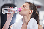 Gym, fitness and woman with earphones drinking water from bottle, cardio workout while listening to music on streaming radio. Sports, exercise and drink of water for healthy lifestyle while training.