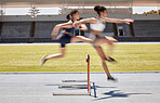 Fitness, race and hurdles with a black woman and sports athlete racing on a track for endurance competition. Motion blur, energy or running with a female and rival or competitor jumping over a hurdle