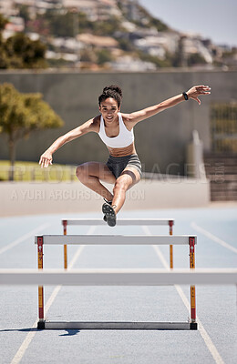 Buy stock photo Fitness, training and woman jumping hurdles for sports, exercise and intense cardio on a running track. Black woman, running and hurdling workout for speed, energy and physical performance at stadium