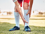 Shin pain, injury and accident of a soccer player playing a match or training on an outdoor field. Fitness, football and athlete with injured, sprain or sore leg for medical emergency at sports game.