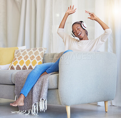 Buy stock photo Black woman, headphones and happy on couch, for dancing and listening to music in living room with smile. Headset, African American girl and female streaming audio, radio and on sofa for happiness.