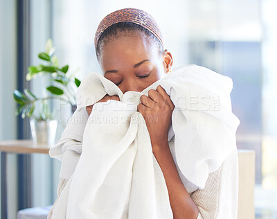 Buy stock photo Linen, cleaning and fresh with a black woman smelling fabric or textile while working in a home as a cleaner. Laundry, housekeeping and scent with a female maid at work with soft sheets to smell