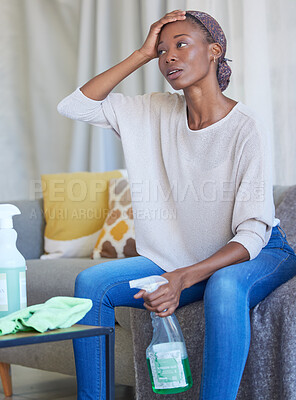 Buy stock photo House cleaning, black woman and tired person in a living room with stress and anxiety from home work. Dust, cleaner and maid service of a young female with dust spray and housekeeping wash product