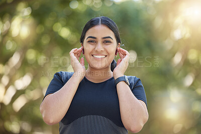 Buy stock photo Music, fitness and woman with smile for earpods during training, exercise or running in a park. Podcast, motivation and portrait of an Indian runner happy during an outdoor workout in nature