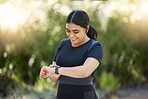 Woman, smartwatch and nature park running training, cardio exercise and fitness health with a smile. Happy summer outdoor sport workout, blurred green background and healthy runner in summer sunshine