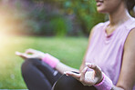 Hands, meditation and fitness with a black woman athlete sitting on a field of grass for zen or wellness. Yoga, nature and meditate with a female yogi training in a park for balance or health