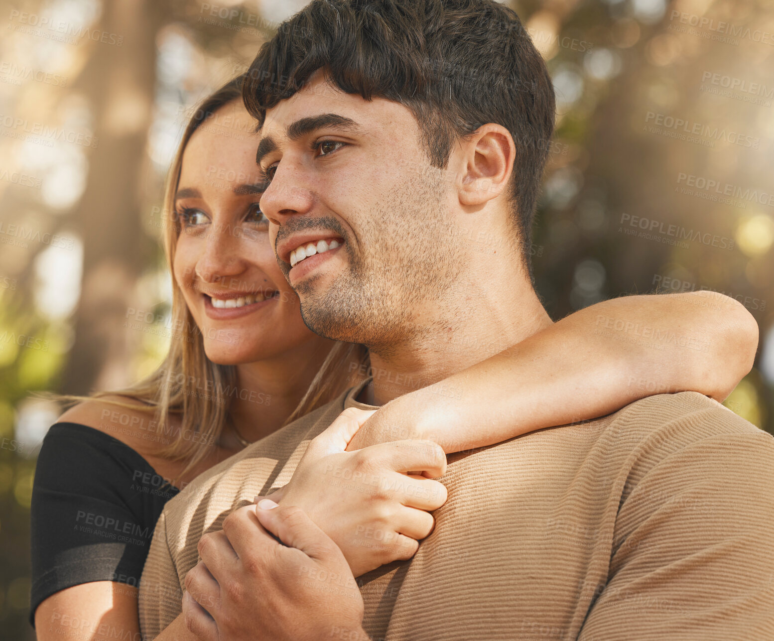 Buy stock photo Love, happy and park with a couple hugging outdoor while enjoying the view together in nature. Face, bonding and date with a young male and female outside on a sunny summer day with affection