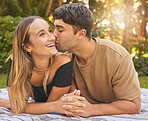 Couple, holding hands with kiss and love in the park, picnic for bonding and happy in nature together. Support, trust and care with romantic date and outdoor fun, commitment and happiness.