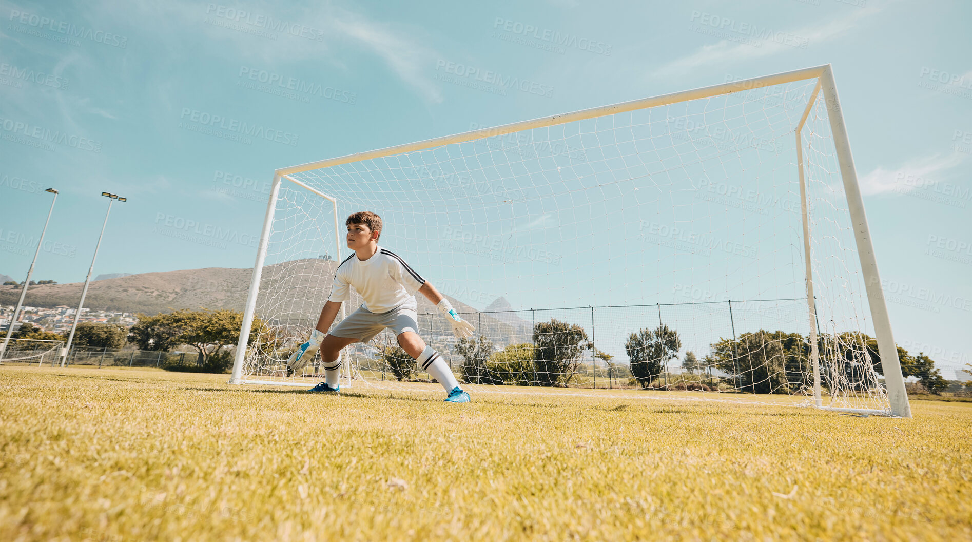 Buy stock photo Boy, soccer field or goalkeeper in fitness game, exercise match or training competition in sports club, school ground or campus grass. Child, kid or football player in net post on park football field